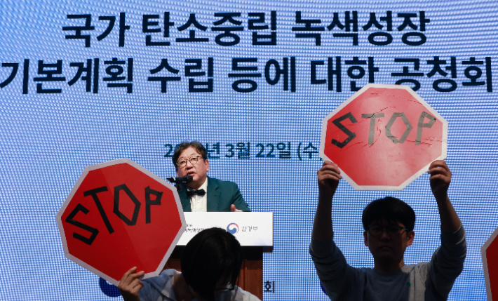 기후위기비상행동을 비롯한 환경단체 회원들이 지난달 22일 서울 강남구 한국과학기술회관에서 열린 탄소중립녹색성장위원회와 환경부의 '국가 탄소중립 녹색성장 기본계획 정부안' 첫 공청회에 참석해 김상협 탄소중립녹색성장위원회 민간위원장의 발언 때 기습 손팻말·펼침막 시위를 벌이고 있다. 연합뉴스