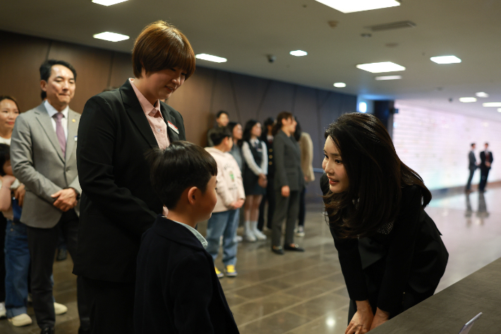  김건희 여사가 13일 서울 63컨벤션센터에서 열린 '히어로즈 패밀리 프로그램' 출범식에서 K-9 자주포 사격훈련 중 폭발사고로 순직한 고(故) 이태균 상사의 자녀와 대화하고 있다. 대통령실 제공 