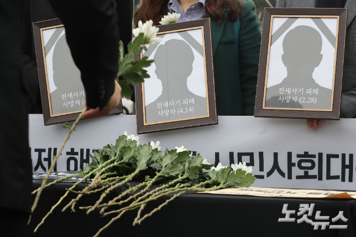 18일 서울 용산구 전쟁기념관 앞에서 열린 전세사기·깡통전세 문제 해결을 위한 시민사회대책위원회 출범 기자회견에서 참석자들이 피해 사망자들을 추모하며 헌화하고 있다. 류영주 기자