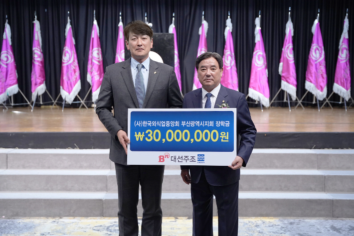 대선주조 최홍성 전략기획실장(왼쪽)이 한국외식업중앙회 강인중 부산광역시지회장에게 장학금 3천만 원을 전달하고 기념사진을 찍고 있다. 대선주조 제공