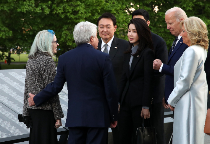 미국을 국빈 방문한 윤석열 대통령과 김건희 여사가 25일(현지시간) 워싱턴DC 한국전 참전용사 기념공원의 추모의 벽 앞에서 조 바이든 미국 대통령 내외와 함께 루터 스토리 상병의 유족을 위로하고 있다. 연합뉴스