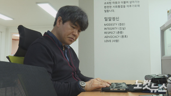 손창환씨가 점자 정보 단말기를 사용해 업무 내용을 확인하고 있다.