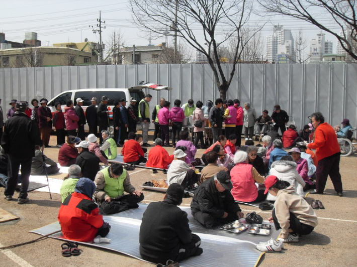 2009년 4월 광명의집 노숙인들이 인천 서구 콜롬비아공원에서 노숙인과 마을 주민에게 무료 점심식사를 배식하는 모습. 광명의집 제공