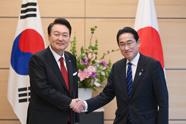 기시다 일본 총리(오른쪽)와 악수하는 윤석열 대통령. 연합뉴스