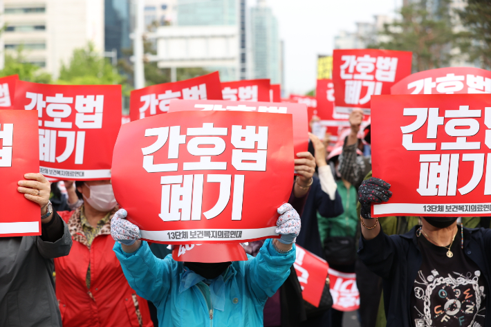 대한의사협회를 비롯한 13개 보건복지의료연대 관계자들이 3일 오후 국회 인근에서 열린 '간호법·면허박탈법 강행처리 더불어민주당 규탄대회'에서 팻말을 들고 있다. 연합뉴스