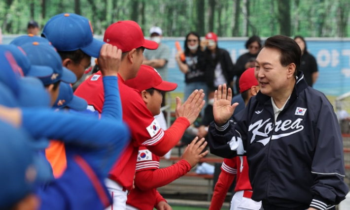 윤석열 대통령이 휴일인 14일 서울 용산 어린이정원 내 어린이야구장에서 열린 2023 대통령실 초청 전국 유소년 야구대회 서울 가동초- 대전 신흥초 결승 경기에 앞서 어린이 야구선수들과 손을 마주치며 격려하고 있다. 연합뉴스