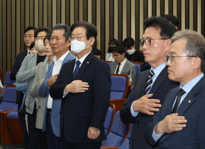 더불어민주당 이재명 대표와 박광온 원내대표가 14일 국회에서 열린 당 의원총회에 참석해 국기에 경례하고 있다. 연합뉴스