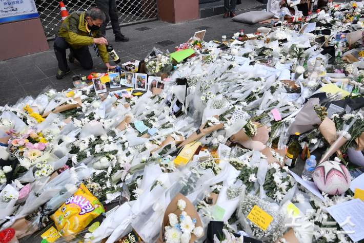 지난해 11월 3일 서울 용산구 이태원역 1번 출구 앞에 마련된 이태원 참사 희생자 추모 공간에서 시민들이 희생자들을 추모하고 있다. 류영주 기자