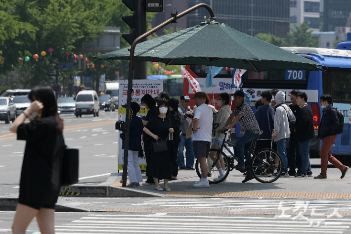 낮 기온이 크게 오르며 초여름 날씨를 보인 15일 서울 광화문광장에서 시민들이 그늘막에서 햇빛을 피하고 있다. 박종민 기자