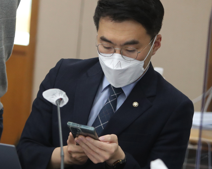 2022년 10월 14일 당시 더불어민주당 김남국 의원이 대전고등법원에서 열린 법제사법위원회 비수도권 지법·고법 국정감사장에서 스마트폰을 확인하고 있다. 연합뉴스