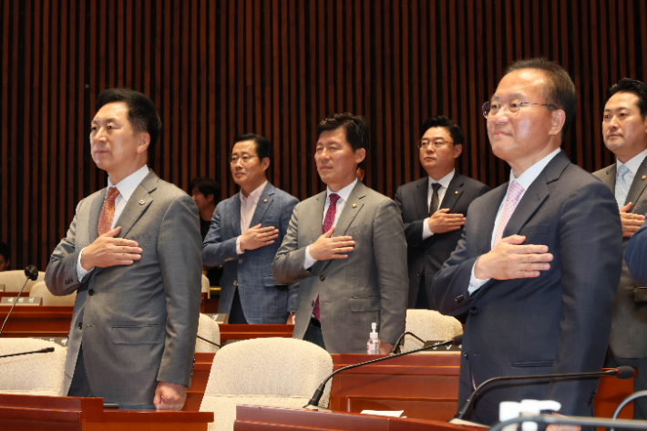 국민의힘 김기현 대표와 윤재옥 원내대표가 17일 오후 국회에서 열린 의원총회에서 국기에 경례하고 있다. 연합뉴스