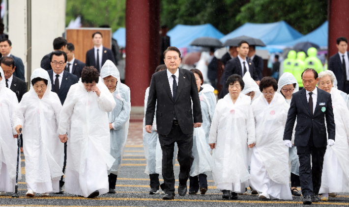 윤석열 대통령이 18일 광주 북구 국립5·18민주묘지에서 열린 제43주년 5·18민주화운동 기념식에 오월어머니회 회원들과 함께 입장하고 있다. 연합뉴스