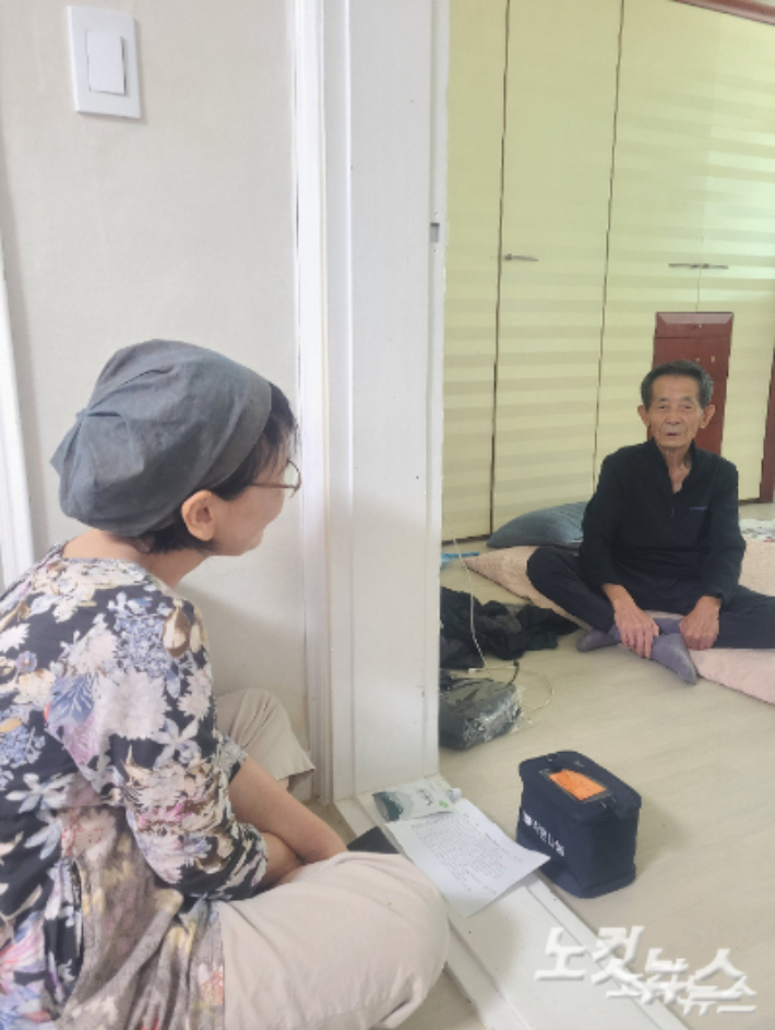 '작은 나눔' 봉사자 박은영(63,여)씨가 지난 23일 김창선(77)씨에게 무료 도시락을 주고 안부를 묻고 있다. 고무성 기자
