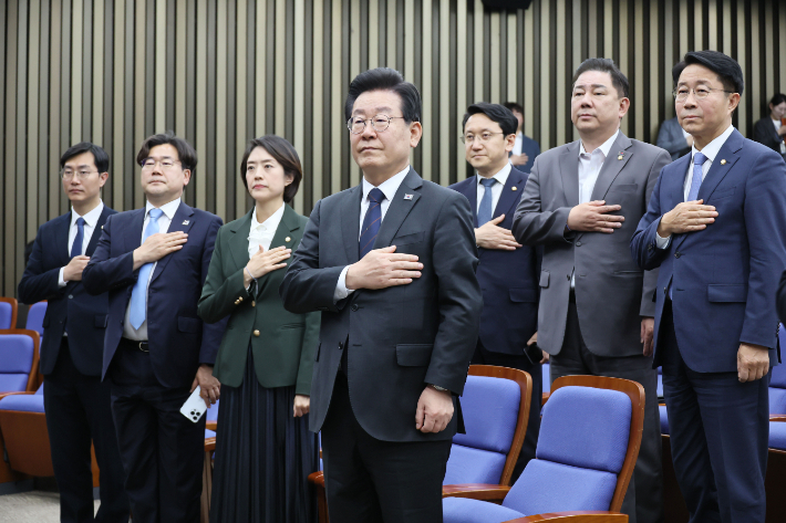 더불어민주당 이재명 대표가 25일 오후 국회에서 열린 의원총회에서 국기에 경례하고 있다. 연합뉴스