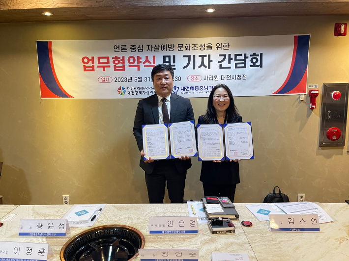 황윤성 대전세종충남기자협회장(왼쪽)과 권국주 대전광역자살예방센터장이 협약을 체결하고 기념촬영을 하고 있다. 대전세종충남기자협회 제공
