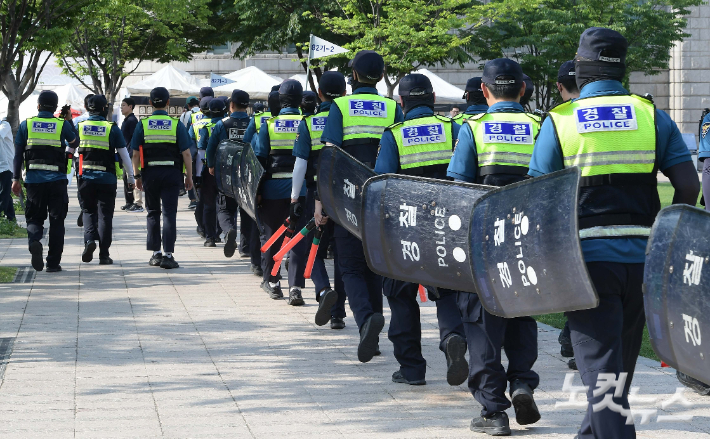전국민주노동조합총연맹 조합원들이 지난달 31일 서울 태평로 일대에서 열린 경고파업 결의대회를 진행하고 있는 가운데 경찰 병력이 이동하고 있다. 박종민 기자