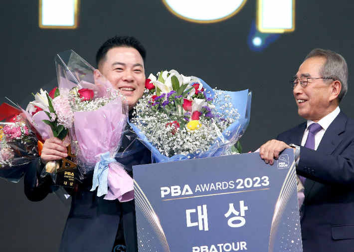 조재호(왼쪽)가 '2022-23시즌 프로당구 PBA 대상 시상식'에서 남자부 영예의 대상을 안은 뒤 PBA 김영수 총재로부터 트로피를 받고 기뻐하고 있다. PBA 