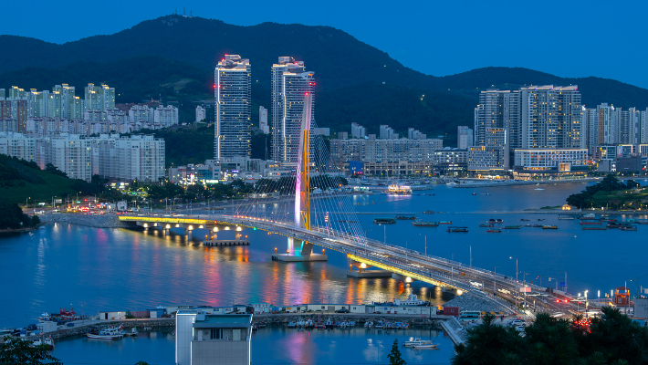 여수 소호~웅천을 연결하는 선소대교 뒤편으로 웅천 생활형숙박시설들이 불을 밝히고 있다. 여수시 제공