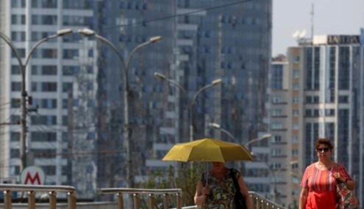 지난 5일 러시아 시베리아 도시 노보시비르스크의 기온이 지난 1956년 이후 가장 높은 섭씨 영상 34.3도까지 치솟은 가운데 한 주민이 더위를 피해 양산을 쓰고 있다. 연합뉴스