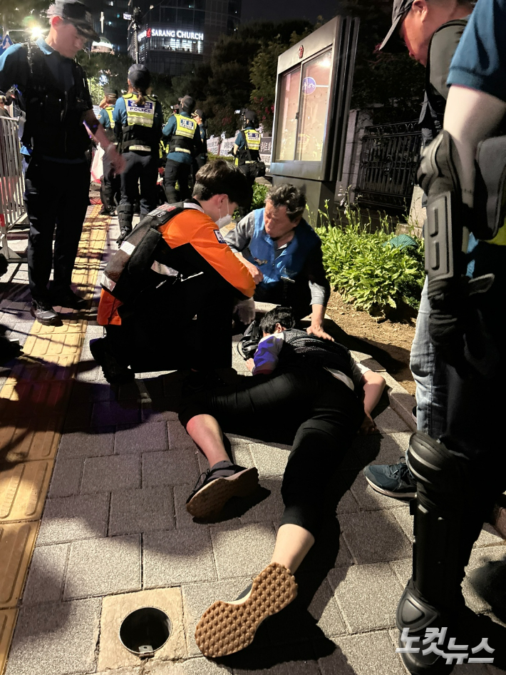 9일 서울 서초구 대법원 앞에서 2차 야간문화제를 진행하던 중 경찰에 의해 강제로 끌려나온 시민이 통증을 호소하고 있다.