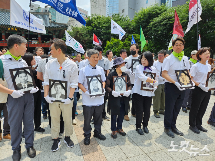 민주열사추모제에 참석한 시민들이 영정사진을 들고 행진을 시작했다. 김정록 기자