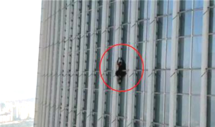 한 외국인 남성이 12일 오전 서울 송파구 롯데월드타워를 무단으로 등반하고 있다. 송파소방서 제공