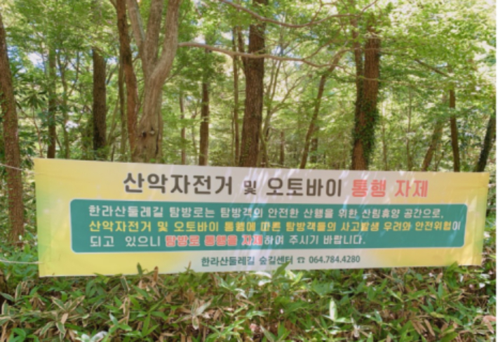 산악자전거와 오토바이의 통행을 자제해달라는 내용의 현수막이 한라산둘레길에 붙어 있다. 제주도 제공