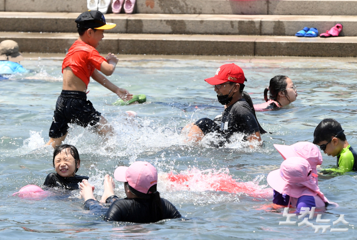 서울 전역에 올해 첫 폭염주의보가 내려진 18일 오후 서울 여의도 한강공원 물빛광장을 찾은 시민들이 물놀이를 하고 있다. 폭염주의보는 최고 체감온도 33도를 웃도는 상태가 이틀 이상 지속될 것으로 예상될 때 내려진다. 황진환 기자
