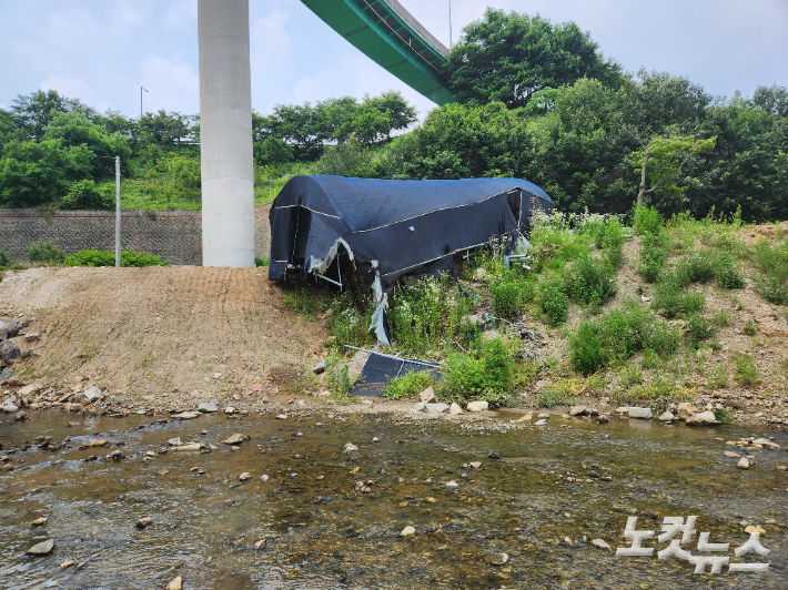 지난해 폭우로 낭떠러지까지 떠내려 온 비닐하우스. 이준석 기자