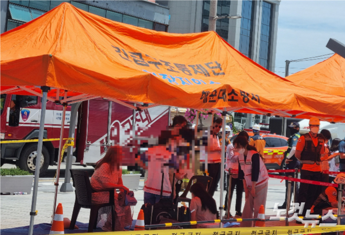 20일 오전 부산 해운대구 한 호텔 건물에서 불이 나 소방관들이 현장에서 응급 처치를 하고 있다. 김혜민 기자 