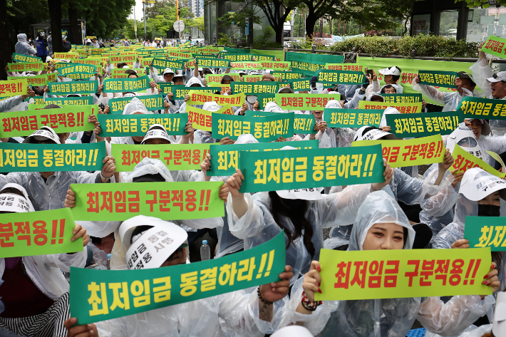 21일 오후 서울 국회의사당역 인근에서 열린 최저임금 동결 촉구 결의대회에서 소상공인연합회원들이 관련 손피켓을 들어보이고 있다. 연합뉴스