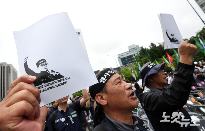 21일 오후 서울 종로구 동화면세점 앞에서 엄수된 건설노조 간부 고(故) 양회동 열사의 영결식에 참석한 건설노조 조합원들이 양 열사의 사진을 들고 구호를 외치고 있다. 황진환 기자