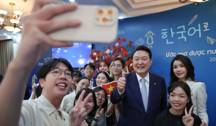 윤석열 대통령과 김건희 여사가 22일 하노이 국가대학교 별관에서 열린 베트남 한국어 학습자와 대화에서 참석자들과 기념사진을 찍고 있다. 연합뉴스