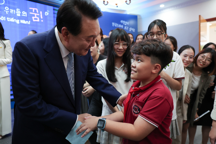 윤석열 대통령이 22일 하노이 국가대학교 별관에서 열린 베트남 한국어 학습자와 대화에서 참석자들과 인사를 나누고 있다. 연합뉴스