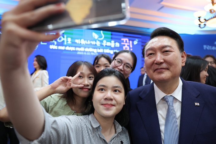 윤석열 대통령이 22일 하노이 국가대학교 별관에서 열린 베트남 한국어 학습자와 대화에서 참석자들과 기념사진을 찍고 있다. 연합뉴스