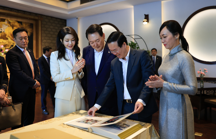 베트남을 국빈 방문 중인 윤석열 대통령과 부인 김건희 여사가 24일 하노이 호안끼엠 호수 인근 식당에서 열린 보 반 트엉 베트남 국가주석 내외와 친교 조찬에서 사진 앨범을 선물받고 있다. 연합뉴스