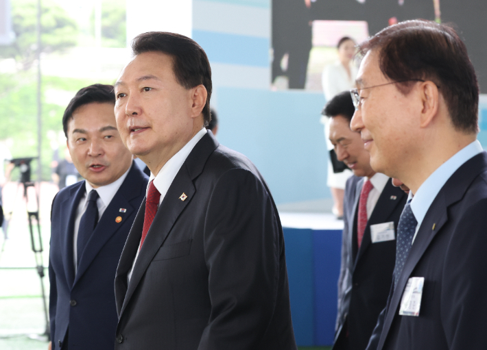 윤석열 대통령이 30일 경기 고양시 어울림누리 별무리경기장에서 열린 '서해선 대곡-소사 복선전철' 개통 기념식을 마친 뒤 이동하며 원희룡 국토교통부 장관과 대화하고 있다. 뒤에는 김기현 국민의힘 대표. 연합뉴스