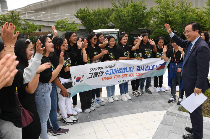 지난 2월에 입국한 필리핀 계절근로자 29명이 5개월 동안의 근로를 마치고 출국 전 유희태 전북 완주군수와 인사하고 있다. 완주군 제공