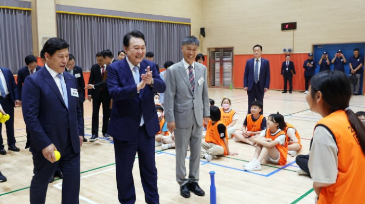 윤석열 대통령이 방과후 돌봄·교육 프로그램인 '늘봄학교' 참관을 위해 3일 경기도 수원초등학교를 방문, 전직 프로야구 선수들이 강사로 초등학생들을 지도하는 간이야구 프로그램을 지켜보고 있다. 연합뉴스