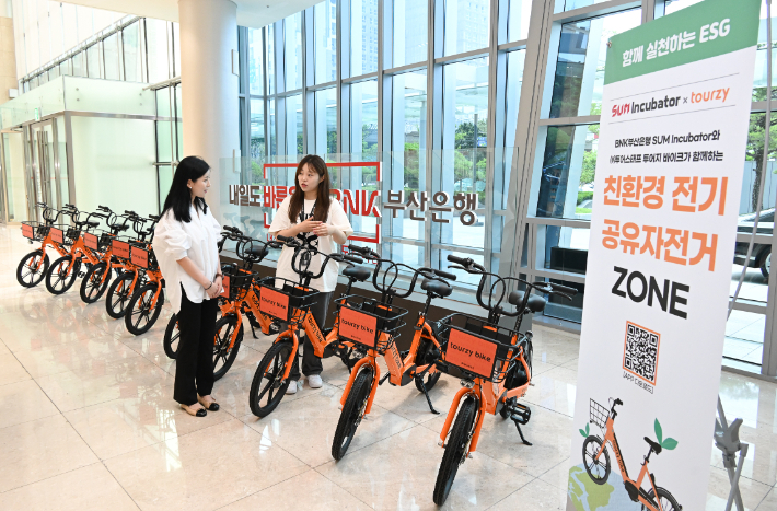 BNK부산은행이 지역 친환경 스타트업 '투어스태프'가 신규 운영하는 전기 공유자전거를 부산은행 본점 1층에 전시했다. 부산은행 제공
