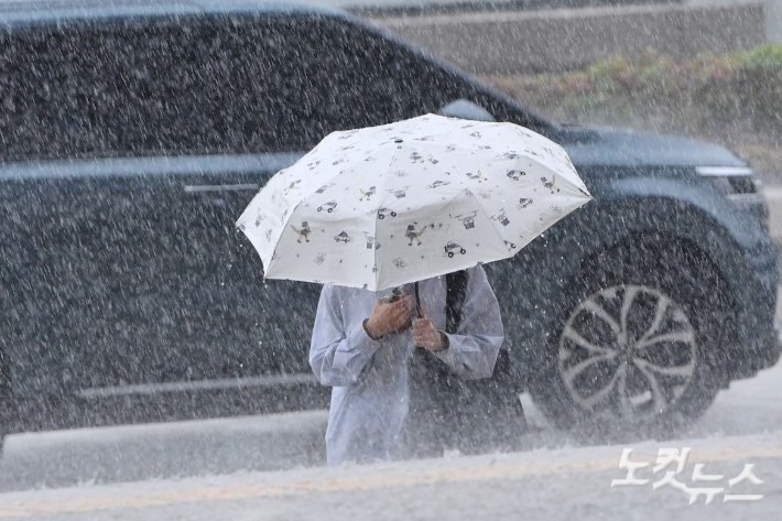 서울 대부분의 지역에 호우주의보가 내려진 9일 서울 여의도 국회에 우산을 쓴 시민이 발걸음을 재촉하고 있다. 류영주 기자