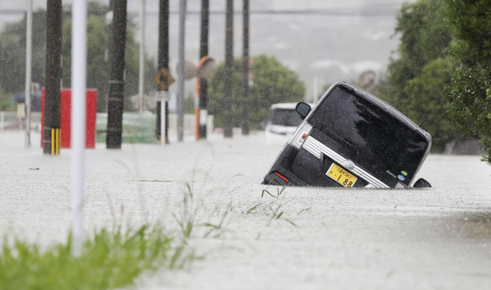지난 10일 일본 북규슈 지역을 강타한 폭우로 하천이 범람해 자동차가 침수된 모습. 연합뉴스