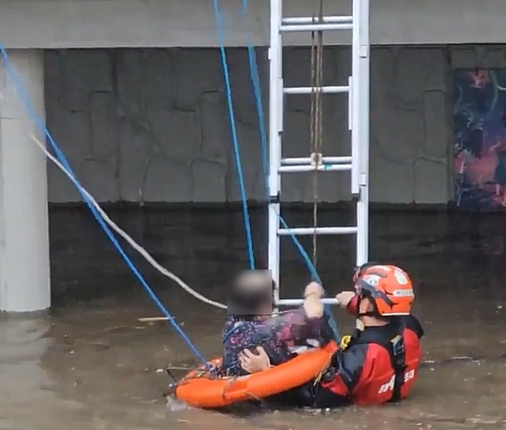 11일 오후 부산 사상구 학장천에 고립됐던 60대 여성을 119구조대가 구조하고 있다. 부산소방재난본부 제공