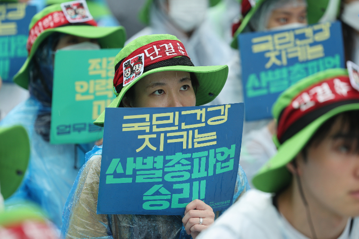  전국보건의료산업노조(보건의료노조) 조합원들이 13일 오후 서울 종로구 세종대로 일대에서 열린 산별 총파업 대회에서 인력·공공의료 확충, 간호간병통합서비스 전면 해결 등을 촉구하고 있다. 연합뉴스