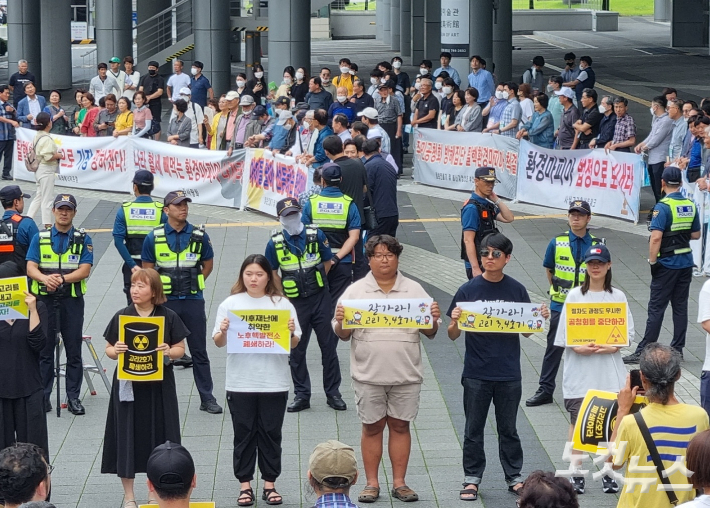 13일 오후 부산 해운대구 벡스코 제2전시장 앞에서 고리3·4호기 수명연장에 반대하는 환경단체 회원들(앞)과 찬성하는 부산 기장군 주민들(뒤)이 동시에 기자회견을 열고 있다. 박진홍 기자