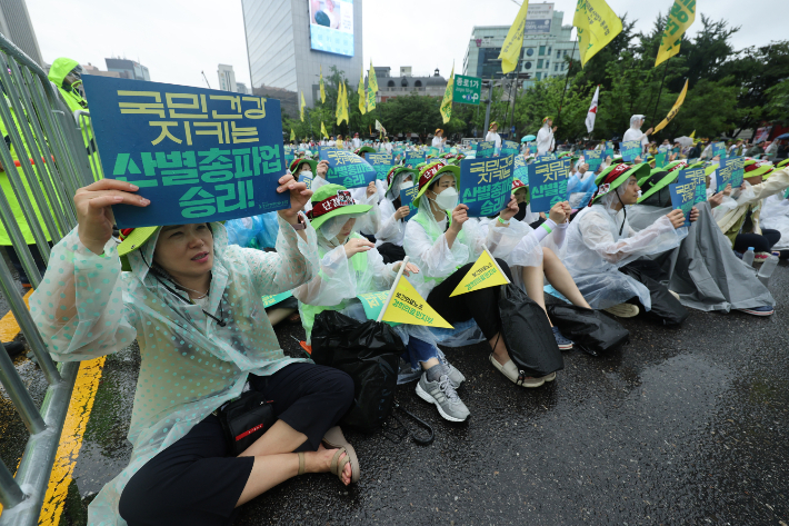 전국보건의료산업노조(보건의료노조) 조합원들이 13일 오후 서울 종로구 세종대로 일대에서 열린 산별 총파업 대회에서 인력·공공의료 확충, 간호간병통합서비스 전면 해결 등을 촉구하고 있다. 연합뉴스