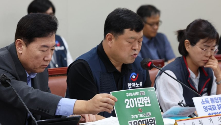 사용자위원인 류기정 한국경영자총협회 전무(왼쪽)가 13일 오후 세종시 정부세종청사 최저임금위원회 회의실에서 열린 제13차 전원회의에서 근로자위원인 류기섭 한국노총 사무총장의 발언 중 최저임금 인상이 무리라는 입장이 적힌 손팻말을 잡고 있다. 연합뉴스