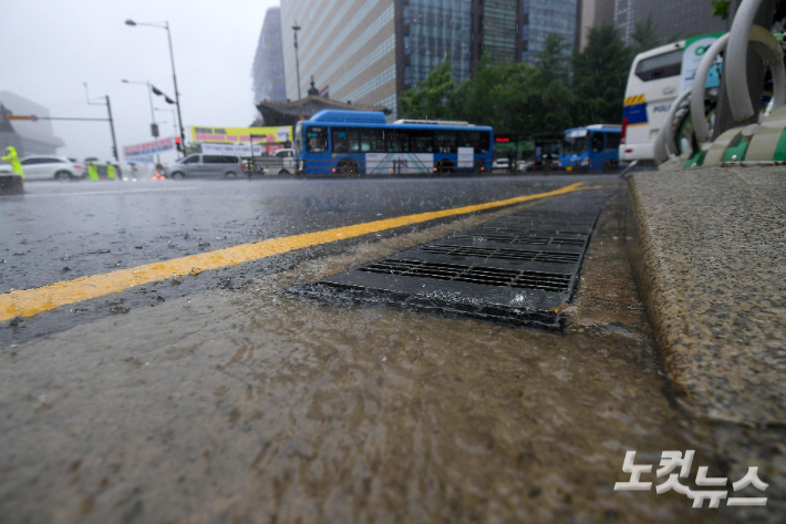 많은 장맛비가 내린 13일 서울 광화문사거리 배수구로 빗물이 흘러들어가고 있다. 박종민 기자