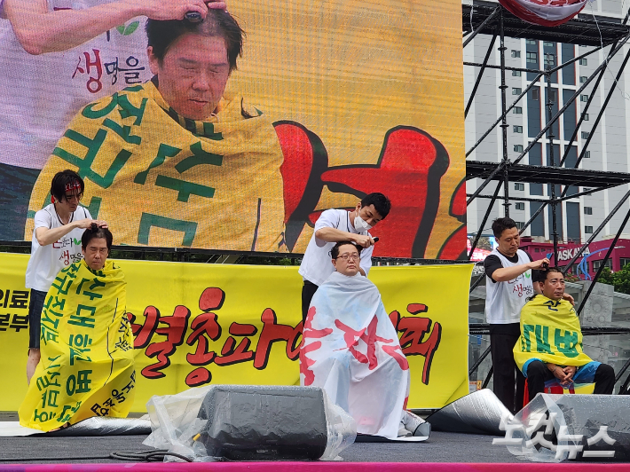 직접고용 전환 등을 요구하며 파업에 돌입한 부산대학교병원 노조 관계자들이 14일 부산역 광장에서 파업출정식을 열며 삭발하고 있다. 정혜린 기자