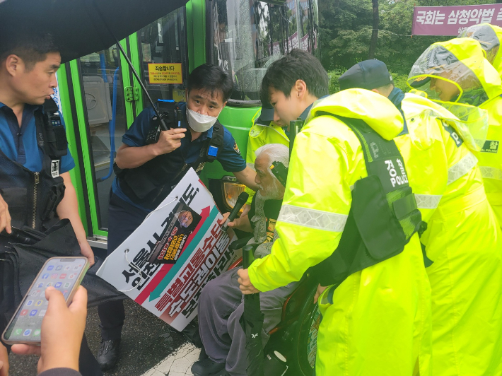 전국장애인차별철폐연대 박경석 상임공동대표가 14일 여의도 글래드호텔 앞에서 버스 앞을 가로막아 운행을 방해한 혐의로 현행범 체포되고 있다. 경찰청 제공